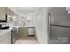Well-lit kitchen with stainless steel appliances, modern flooring, and bright white cabinets at 2712 New Hamlin Way, Charlotte, NC 28210