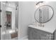 Modern bathroom with gray vanity and round mirror at 5056 Bridge Way, Denver, NC 28037