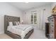 Spacious bedroom with tufted headboard and window at 5056 Bridge Way, Denver, NC 28037