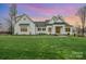 Stunning farmhouse exterior with a beautiful lawn at sunset at 5056 Bridge Way, Denver, NC 28037