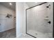 Modern bathroom with walk-in shower featuring marble-style tile and black hardware at 5680 Clear Creek Ln, Charlotte, NC 28215
