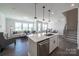 Modern kitchen with a stainless steel dishwasher, a central island and an open view to the living room at 5680 Clear Creek Ln, Charlotte, NC 28215
