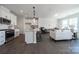 Open-concept living room with a modern kitchen, hardwood floors, and bright, natural light from the surrounding windows at 5680 Clear Creek Ln, Charlotte, NC 28215
