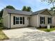 Charming single-story home with vinyl siding, black shutters, and a concrete driveway on a sunny day at 702 Park Ave, Salisbury, NC 28144
