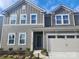 Two-story home featuring a gray exterior, a two-car garage, and a manicured front yard at 14042 Aikenwood Dr, Charlotte, NC 28278