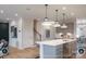 Modern open kitchen featuring an island with pendant lighting and stainless steel appliances, seamlessly connects to the living and dining areas at 14042 Aikenwood Dr, Charlotte, NC 28278