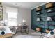 Bright home office featuring a large window, modern desk setup, and decorative shelving against a dark accent wall at 14042 Aikenwood Dr, Charlotte, NC 28278