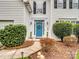 Close up view of white home with blue front door, green bushes, a dog statue and walkway at 17628 Cambridge Grove Dr, Huntersville, NC 28078