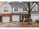 Tan and brick townhouse with a two-car garage and neat landscaping at 2022 University Heights Ln, Charlotte, NC 28213