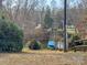 Backyard view featuring a boat parked near a pond, surrounded by lush greenery at 3433 Spinner Ct, Sherrills Ford, NC 28673