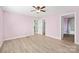 Spacious bedroom with pink walls, wood-look flooring, ceiling fan, and views to the ensuite bathroom at 3433 Spinner Ct, Sherrills Ford, NC 28673