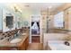 Bright bathroom featuring double sinks, granite countertops, and a glass-enclosed shower with a separate tub at 4008 Saphire Ln, Indian Trail, NC 28079