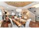 A dining room featuring a wooden table, modern chandelier, accent wall, and a view of the living area at 4008 Saphire Ln, Indian Trail, NC 28079