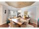 A dining room with a wooden table and chairs, featuring a decorative ceiling and modern lighting at 4008 Saphire Ln, Indian Trail, NC 28079