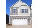 Two-story townhome with gray siding, stone accents, and a two-car garage at 4027 Lawnview Dr, Charlotte, NC 28269