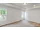 A carpeted bedroom features white walls, a tray ceiling and two windows providing natural light at 4031 Lawnview Dr, Charlotte, NC 28269