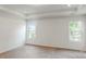 A carpeted bedroom features white walls, a tray ceiling and two windows, providing ample natural light at 4031 Lawnview Dr, Charlotte, NC 28269