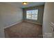 Bright bedroom with neutral walls, plush carpeting, and a window offering natural light at 5544 Stafford Rd # 30, Charlotte, NC 28215