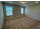 Carpeted bedroom with two large windows, neutral paint, and ample natural light at 5544 Stafford Rd # 30, Charlotte, NC 28215