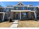 Charming brick townhome featuring gray shutters, a covered porch, and well-manicured landscaping at 5544 Stafford Rd # 30, Charlotte, NC 28215