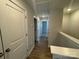 Upstairs hallway with hardwood floors, neutral paint, and multiple doors leading to bedrooms at 5544 Stafford Rd # 30, Charlotte, NC 28215