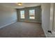 A bright bedroom featuring two windows, neutral walls and carpet, and a ceiling light at 5548 Stafford Rd # 29, Charlotte, NC 28215