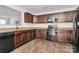 Well-equipped kitchen featuring dark wood cabinets, granite countertops, and modern black appliances at 980 Von Buren Blvd, Rock Hill, SC 29730