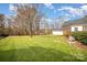 Large backyard with a lush green lawn, mature trees, and partial fencing at 180 Sink Farm Rd, Mooresville, NC 28115