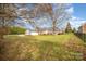 Spacious backyard with lush green grass and a large home and three-car garage in the background at 180 Sink Farm Rd, Mooresville, NC 28115