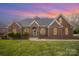 Charming brick home with manicured lawn, arched windows, and covered entry at 180 Sink Farm Rd, Mooresville, NC 28115