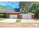 A spacious three car garage featuring white doors on a beautiful brick home at 180 Sink Farm Rd, Mooresville, NC 28115
