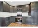 Renovated kitchen boasts dark cabinetry, stainless steel appliances and white quartz countertops at 306 S Jones Ave, Rock Hill, SC 29730