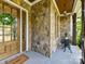 Cozy front porch features stone accents, wooden door with wreath, and seating area at 3227 Pinehurst Pl, Charlotte, NC 28209