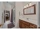 Bright bathroom featuring a classic vanity, framed mirror, and shower with a tiled surround at 4687 Snow Dr, Harrisburg, NC 28075