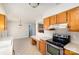 Functional kitchen featuring oak cabinetry, tile floors, and updated appliances at 5328 Caradon Dr, Charlotte, NC 28227