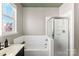 Bright bathroom with a shower, bathtub, and vanity with modern fixtures at 7108 Founders Club Ct, Charlotte, NC 28269