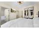 Cozy bedroom with access to en-suite bathroom, decorative lighting, and decorative mirror accent wall at 7108 Founders Club Ct, Charlotte, NC 28269
