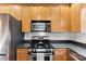 Kitchen featuring stainless steel appliances, light wood cabinets, and dark countertops at 7108 Founders Club Ct, Charlotte, NC 28269