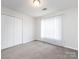 Well-lit bedroom with carpet flooring and double doors leading to closet at 11813 Fox Glen Rd, Charlotte, NC 28269