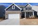 Charming two-story home showcasing a brick and navy siding, a white garage door and a manicured front yard at 2608 Clipper Nw Ct, Concord, NC 28027