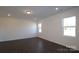 Bright living room with wood-look floors, recessed lights, and big windows at 2612 Clipper Nw Ct, Concord, NC 28027