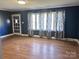 Living room with hardwood floors, blue walls and window curtains at 325 Hunter St, Salisbury, NC 28144