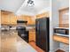 Modern kitchen with granite countertops, black appliances, and wood cabinets at 3706 Selwyn Farms Ln # 17-3, Charlotte, NC 28209