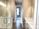 Hallway view of a primary bathroom that has marble countertops, a glass shower, and tile flooring at 143 Dabbling Duck Cir, Mooresville, NC 28117
