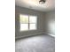 This bedroom features neutral-toned walls and carpeting and a window overlooking a green yard at 143 Dabbling Duck Cir, Mooresville, NC 28117