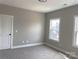 This bedroom features neutral walls and carpeting, a door, and windows overlooking a residential street at 143 Dabbling Duck Cir, Mooresville, NC 28117