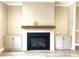 Cozy fireplace with a wood mantle and built-in cabinets creating an inviting focal point in the living room at 143 Dabbling Duck Cir, Mooresville, NC 28117