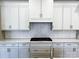 Stylish kitchen featuring white cabinets, stainless steel appliances, and a bright herringbone backsplash at 143 Dabbling Duck Cir, Mooresville, NC 28117