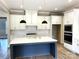 Modern kitchen island with stainless steel appliances and a stylish herringbone backsplash at 143 Dabbling Duck Cir, Mooresville, NC 28117
