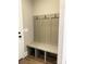 Hall tree with bench and coat hooks in a light-filled mudroom with wood flooring at 143 Dabbling Duck Cir, Mooresville, NC 28117